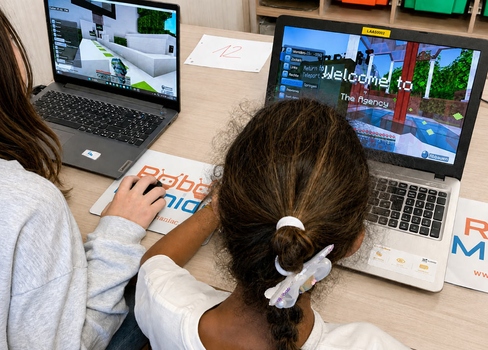 Zwei Kinder, die im Minecraft-programmieren-Feriencamp sitzen