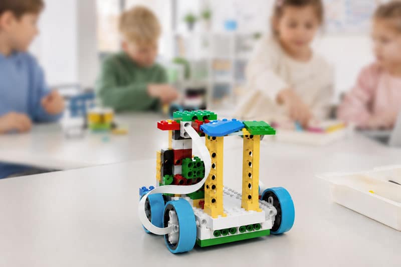 Mitten im Lego Education Spike Kurs, 4 Kinder im Hintergrund mit Lego Robotik