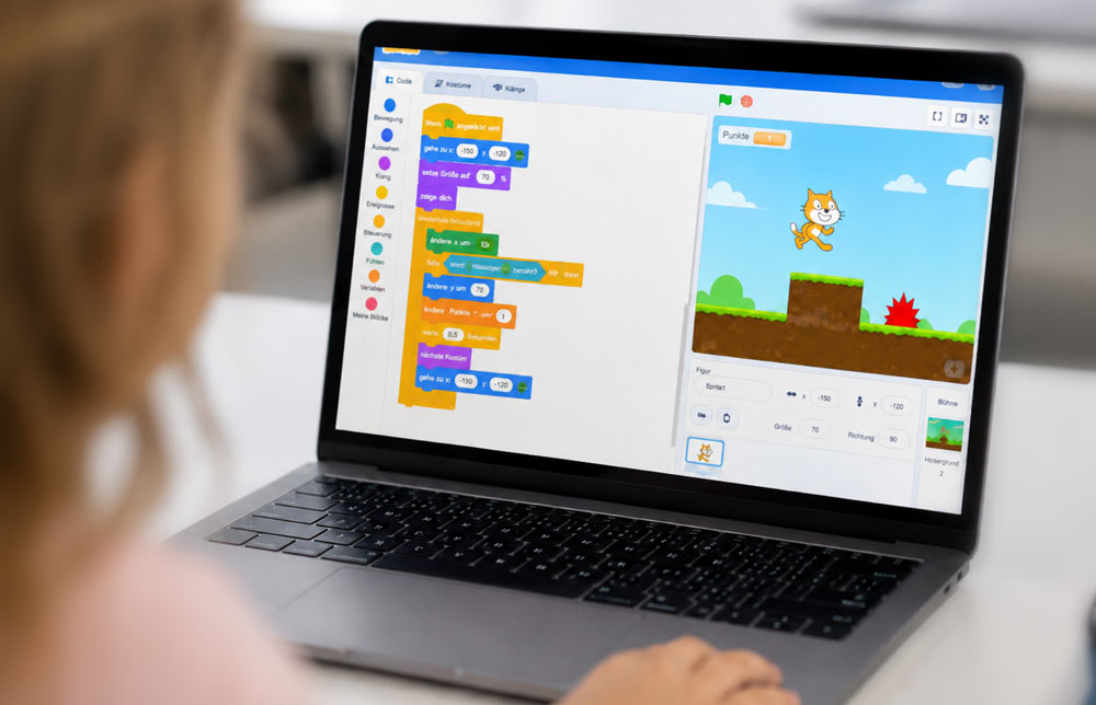 8jährige die am Laptop ein Spiel mit Scratch programmiert