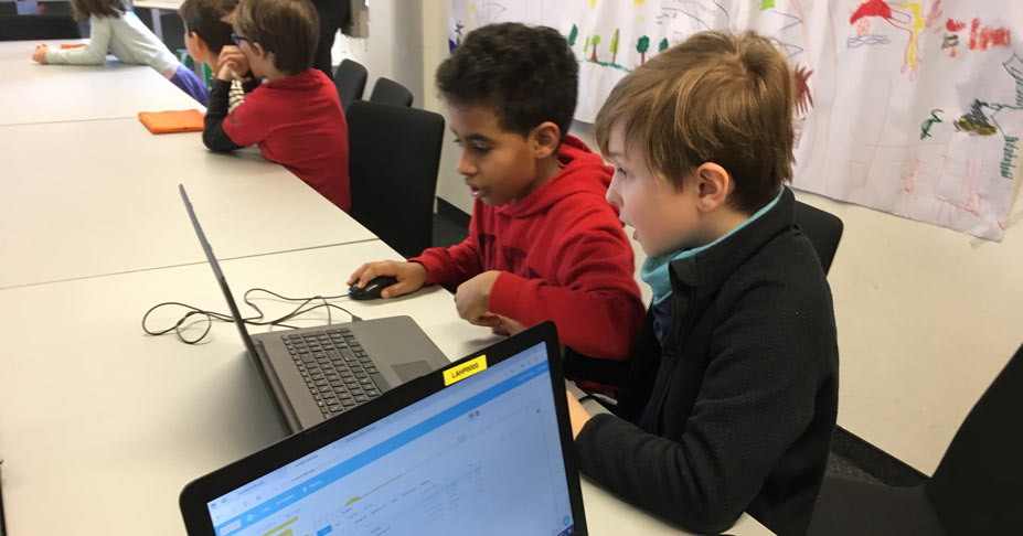 Kinder, die gerade am Computer ihre eigenen Spiele entwickeln